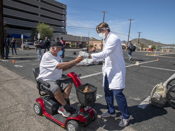 Students in the College of Medicine – Tucson distributed food, water and medical care to the homeless population in downtown Tucson during the pandemic. Pictured here in April near the Z Mansion, a food distribution site for the homeless population several times a week.