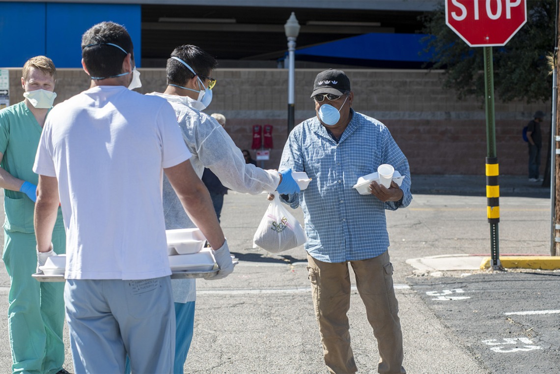 Students in the College of Medicine – Tucson distributed food, water and medical care to the homeless population in downtown Tucson during the pandemic. Pictured here in April near the Z Mansion, a food distribution site for the homeless population several times a week.