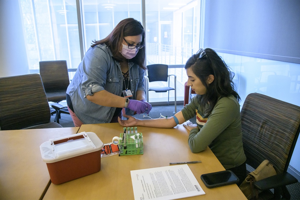 University of Arizona researcher Yvonne Castaneda draws blood from a test subject who has had COVID-19. This helps researchers to verify the accuracy of the antibody test, a key step conducted in April on the path to creating highly accurate tests.