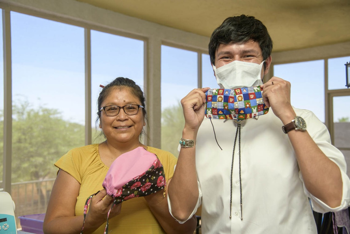 Navajo seamstress Theresa Hatathlie-Delmar and College of Medicine – Tucson student Aaron Bia pose with masks made from donated material.