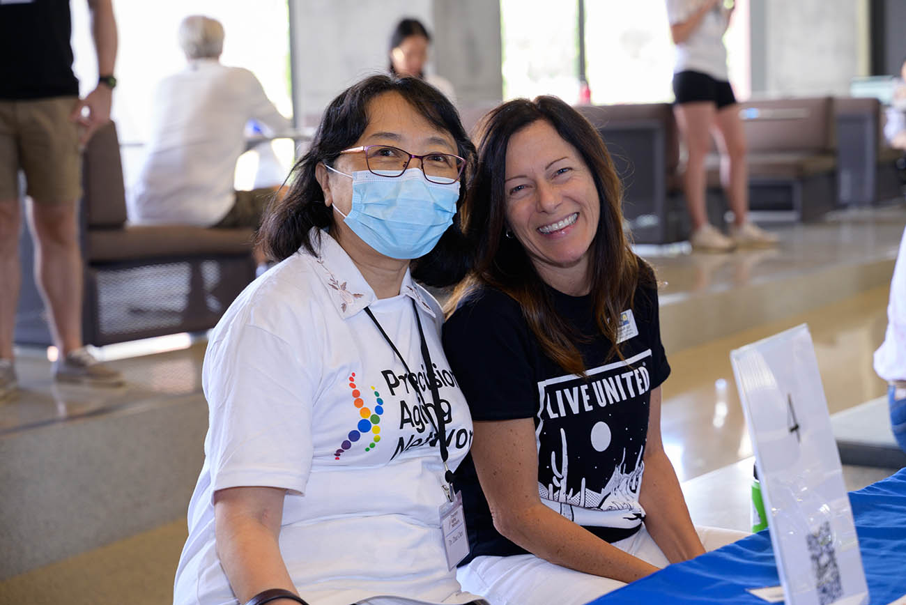 Zhao Chen, PhD, MPH, MEZCOPH professor and associate dean for research, and Elizabeth Cozzi, associate vice president of community development at the United Way of Tucson, pause for a moment at the Feast for Your Brain event.