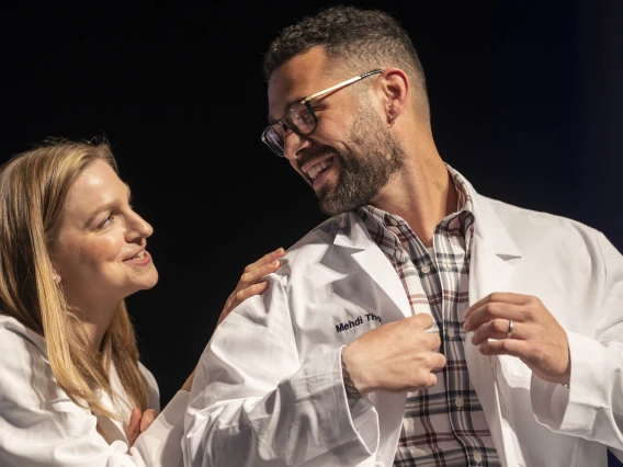 Dr. Lindsay Bouchard congratulates Mehdi Thomas after presenting him with his white coat at the UArizona College of Nursing white coat ceremony.