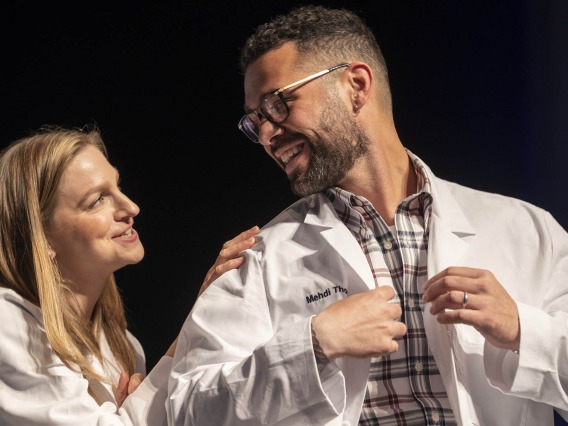 Dr. Lindsay Bouchard congratulates Mehdi Thomas after presenting him with his white coat at the UArizona College of Nursing white coat ceremony.