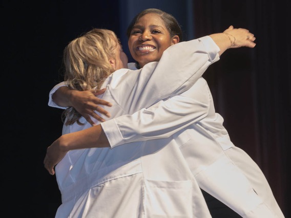 Professor Gloanna Peek hugs Nicole Robinson during the UArizona College of Nursing white coat ceremony.