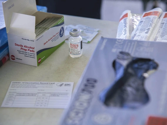 A table is stocked with the essentials: alcohol prep pads, needles, a vaccine card, gloves and Moderna’s COVID-19 vaccine.