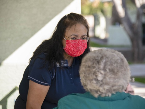 Nancy Alvarez, College of Pharmacy associate dean of academic and professional affairs for Phoenix, speaks with an elderly vaccine recipient from El Mirage Senior Village public housing complex. Patients stay under observation for 15 minutes after receiving the vaccine to make sure there are no adverse reactions.