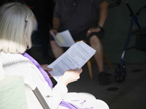 A resident from El Mirage Senior Village reads information about the COVID-19 vaccine as she waits to receive the first dose.