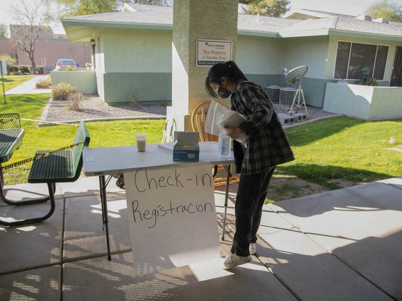 Second-year College of Pharmacy student Lisa Wan helps set up the check-in table in the courtyard of El Mirage Senior Village in El Mirage, Arizona.