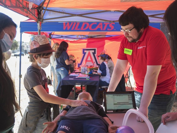 Insee Ekstrom checks to see if Hal, the young manikin, is breathing at the Arizona Simulation Technology and Education Center (ASTEC) booth, where they taught CPR and airway skills during the recent Family SciFest at Children's Museum Tucson.