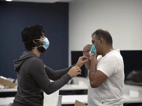 First-year College of Medicine – Tucson student Ahmed Al-Shamari checks second-year student Waheed Asif’s N95 mask to ensure it has a good seal.