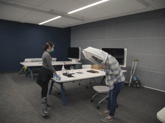 College of Medicine – Tucson student Emerald Montgomery begins a task while wearing the hooded mask with the N95. Afterward, bitters will again be sprayed into the hooded mask. If she can taste them, the equipment is no longer properly fitted.