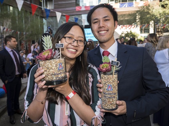 Julie Tran and Diep Nguyen pose for a photo holding each other’s succulent plants that contain their letters before the start of the College of Medicine-Phoenix Match Day 2022 event.