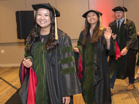 College of Medicine – Phoenix class of 2022 graduates (from front left) Amanda Tjitro, MD, Julie Tran, MD, and Blake Traube, MD, line up to be hooded during their commencement ceremony.