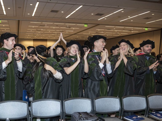 Graduates of the UArizona College of Medicine – Phoenix class of 2022 stand and cheer as their commencement ceremony concludes in the Phoenix Convention Center.