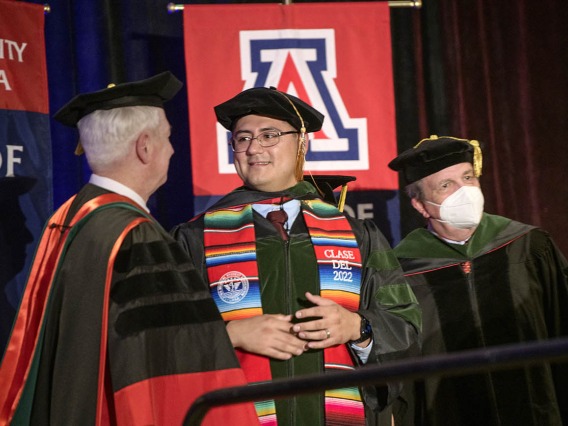 (From left) UArizona College of Medicine – Phoenix Dean Guy Reed, MD, MS, congratulates Jesús Leyva, MD, as they prepare to have a photo taken with Michael D. Dake, MD, senior vice president for Health Sciences at the College of Medicine – Phoenix class of 2022 commencement ceremony.