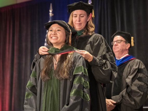 Julie Tran, MD, is hooded by Kathleen Brite Hillis, MD, interim senior associate dean, undergraduate medical education, during the College of Medicine – Phoenix class of 2022 commencement ceremony.