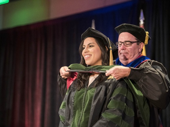 Sokena Batool Zaidi, MD, is hooded by Paul Standley, PhD, associate dean, curricular affairs and program evaluation, during the College of Medicine – Phoenix class of 2022 commencement ceremony.