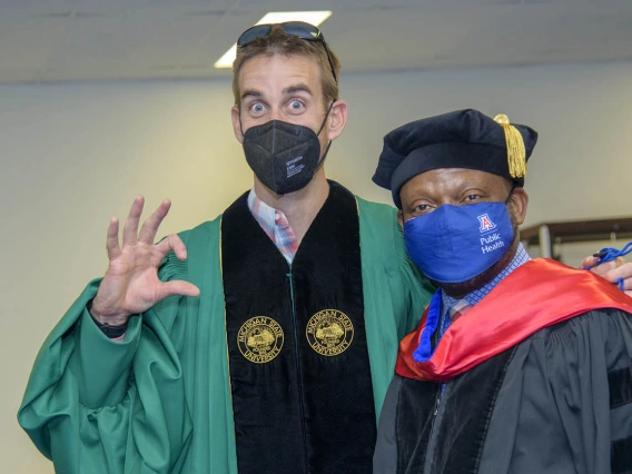 (From left) Marc Verhougstraete, PhD, assistant professor in the Department of Community, Environment and Policy, and John Ehiri, PhD, MPH, MSc, associate dean for academic affairs in the Mel and Enid Zuckerman College of Public Health, get ready for the college’s 2022 spring convocation ceremonies.