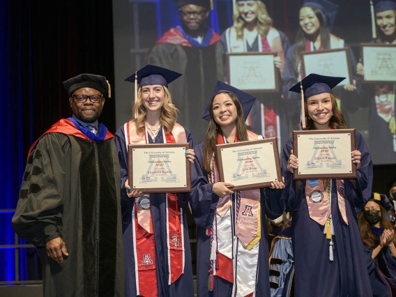 (From left) John Ehiri, PhD, MPH, MSc, associate dean of academic affairs, stands with Bachelor of Science Outstanding Senior Award recipients Elizabeth Beattie, Erin Broas and Allison Rascon during the 2022 Mel and Enid Zuckerman College of Public Health spring convocation. 