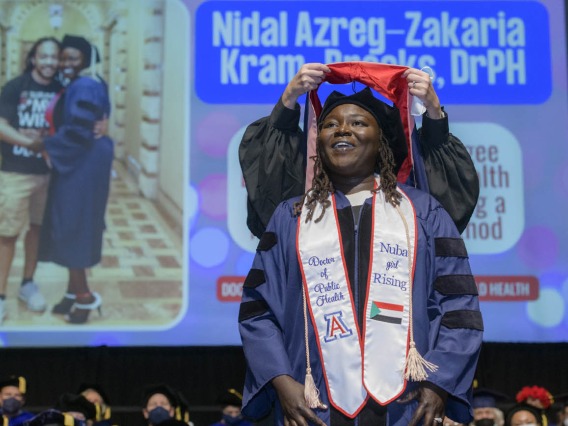 Nidal Azreg-Zakaria Kram-Brooks, DrPH, is hooded during the 2022 Mel and Enid Zuckerman College of Public Health spring convocation.