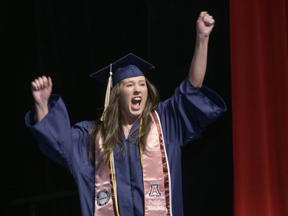 Katelyn Maple cheers as she walks on stage to receive her Bachelor of Science in Public Health during the 2022 Mel and Enid Zuckerman College of Public Health spring convocation.