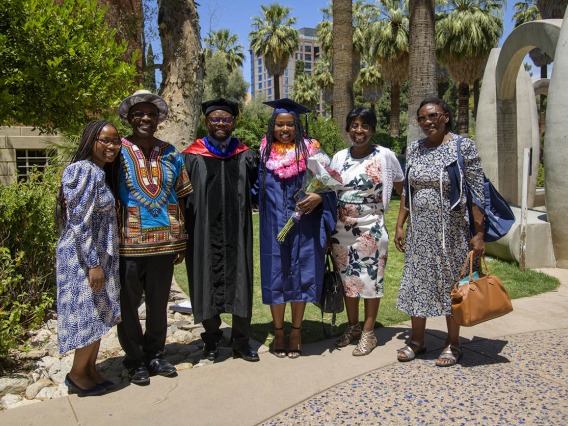 Velma Gesimba, MPH, and her family pose with John Ehiri, PhD, MPH, MSc, associate dean for academic affairs (third from left) after being hooded for earning her Master in Public Health degree during the 2022 spring convocation ceremony for the Mel and Enid Zuckerman College of Public Health.