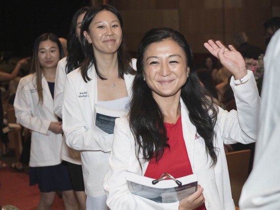Erika Shiho Yasuda waves to her family as she walks out of Symphony Hall after the UArizona College of Medicine – Phoenix Class of 2026 white coat ceremony in downtown Phoenix.