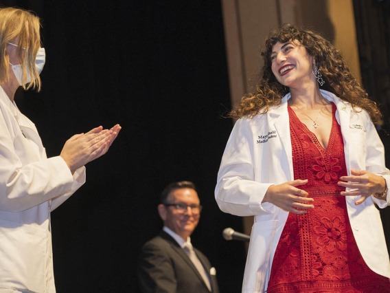 UArizona College of Medicine – Phoenix Associate Dean of Student Affairs Stephanie Briney, DO, applauds after giving Maya Khalil her white coat at the college’s Class of 2026 white coat ceremony.