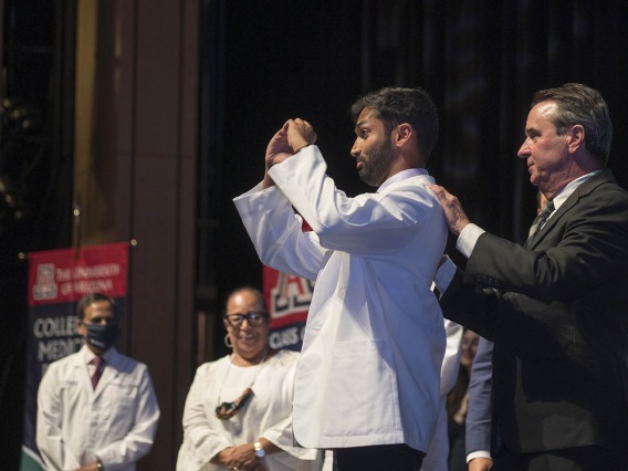 Owais Ahmed Salahudeen makes a heart symbol with his hands after donning his white coat at the UArizona College of Medicine – Phoenix Class of 2026 white coat ceremony.