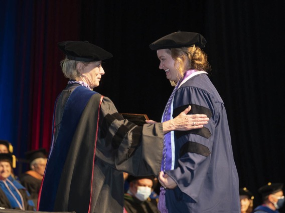 College of Nursing interim Dean Kathleen Insel, PhD, presents Christine Platt with an award for outstanding PhD-DNP candidate during the college’s 2022 summer convocation.
