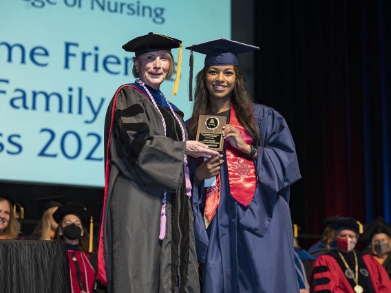 College of Nursing interim Dean Kathleen Insel, PhD, presents the Gladys E. Sorensen Award for Academic Excellence to Leila Darbouze, Master of Science in Nursing Entry to the Profession student, at the college’s 2022 summer commencement.