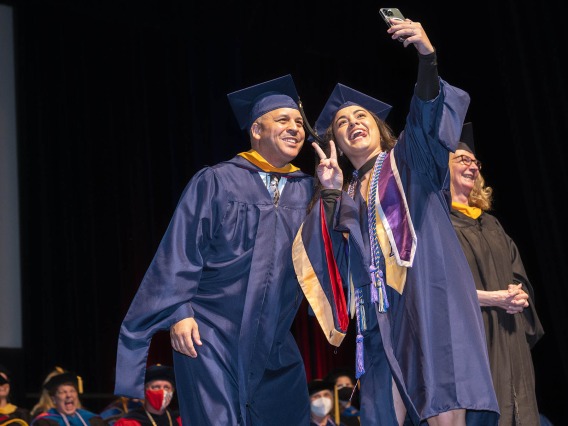 Samantha Galvez, who received her Master of Science in Nursing Entry to the Profession degree, takes a selfie with University of Arizona College of Nursing lecturer John Fraleigh, MSN, CFRN, before being hooded at the college’s summer convocation ceremony Aug. 11 at Centennial Hall.