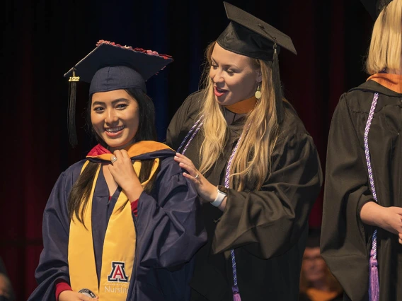 Master of Science in Nursing Entry to the Profession student Tun Pyai So Nef is hooded by Carrie Van Bakel, MSN, during the College of Nursing’s 2022 summer convocation.