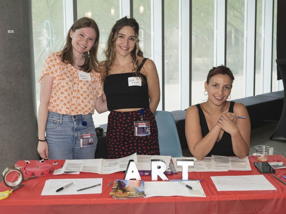 (From left) Annalise Bracher, Dalia Koujah and Maeliss Gelas, medical students in the College of Medicine – Phoenix, welcome visitors to the public opening of the Artist + Researcher exhibition inside the Health Sciences Education Building.