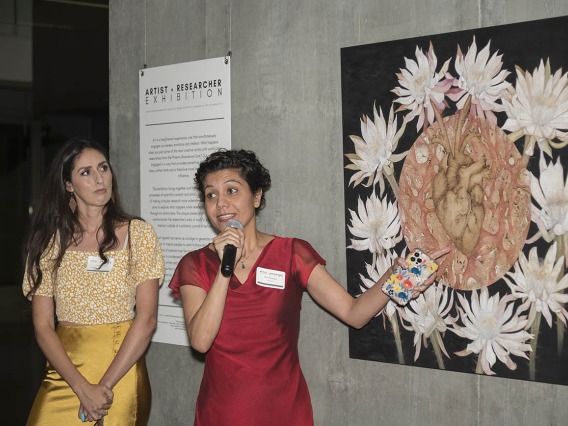 (From left) Artist Alexandra Bowers listens as Shirin Doroudgar, PhD, an assistant professor in the College of Medicine – Phoenix, talks about collaborating on the piece, “Deciphering the Nature of Cardiokines” during the public opening of the Artist + Researcher exhibition inside the Health Sciences Education Building.