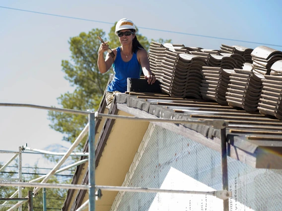 Vivienne Ng, MD, MPH, an assistant professor in the College of Medicine – Tucson’s Department of Emergency Medicine, paints the eaves on a house being built by Habitat for Humanity Tucson during the EM Day of Service.