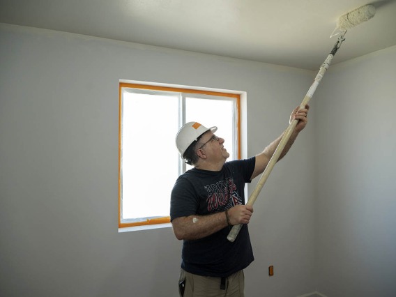 Albert Fiorello, MD, FAAEM, FACEP, an associate professor in the College of Medicine – Tucson’s Department of Emergency Medicine, rolls paint on the ceiling of a Habitat for Humanity house during the EM Day of Service.  