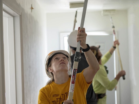 Lindsey Vandergrift, MD, a first-year emergency medicine resident at Banner – University Medical Center Tucson, paints a hallway ceiling in a new Habitat for Humanity Tucson home during the EM Day of Service.