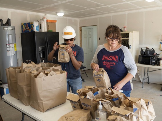 (From left) Tiani Wright, an administrative assistant, and Veronica Calderon, a senior program manager, both from the College of Medicine – Tucson’s Department of Emergency Medicine, organize lunches for EM Day of Service volunteers. 
