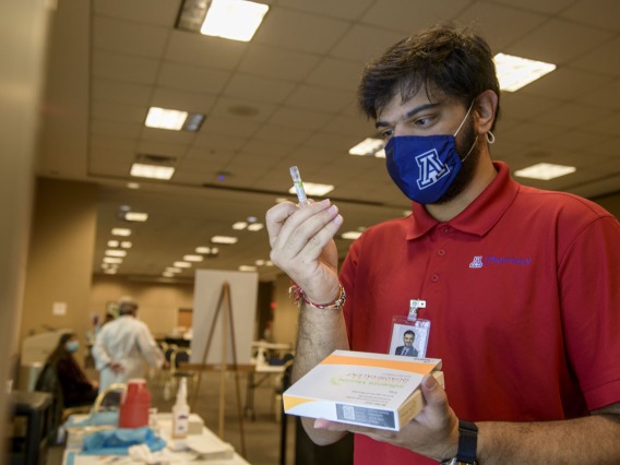 Kishan Hadvani, a PharmD student, prepares a flu vaccination for his next patient. He says he volunteered at the clinic to give back to the community.