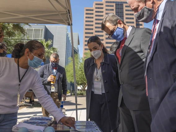 UArizona President Robert C. Robbins, MD, (right) and Mexican Ambassador to the U.S. Esteban Moctezuma Barragán (second from right) examine displays at the U.S. Mexico Binational Health Leadership Summit health fair on the Phoenix Biomedical Campus.