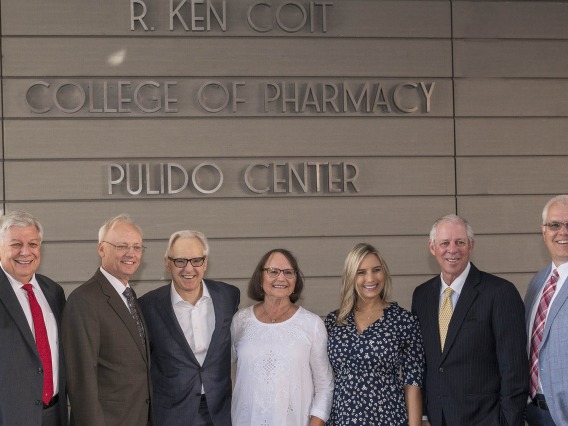 Arizona Board of Regents' Ron Shoopman, College of Pharmacy Dean Dr. Rick G. Schnellmann, R. Ken Coit, Donna Coit, Lauryn Coit Ackley, UArizona President Dr. Robert C. Robbins and UArizona Foundation President and CEO JP Roczniak stand in front of the just-unveiled R. Ken Coit College of Pharmacy signage after the announcement of a $50 million gift from the Coit Family Foundation. 