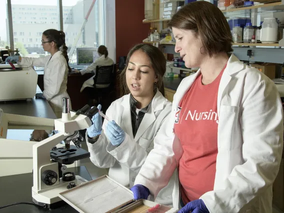 Helena W Morrison, PhD, RN, associate professor of nursing, works with a lab assistant in 2018.