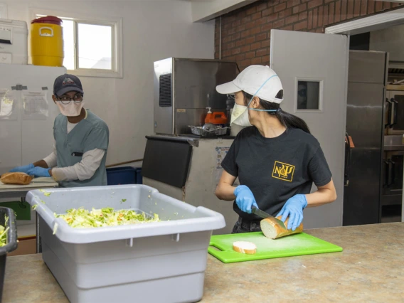 Koustubh Kandapalli and another student prepare meals to distribute to Tucson’s homeless population as part of the College of Medicine – Tucson’s Commitment to Underserved People program.