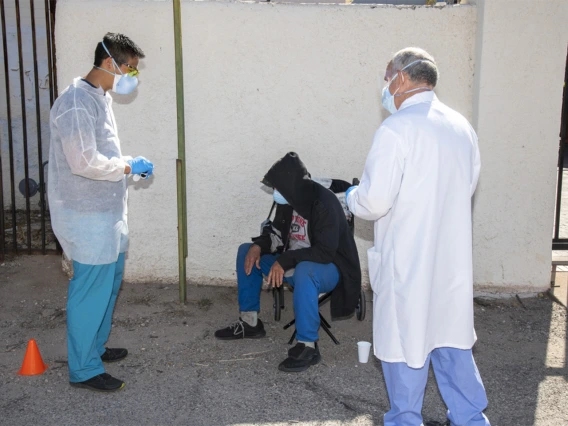 Christian Bergman (left) speaks with a person at Tucson’s Z Mansion downtown soup kitchen. Bergman and other medical students are helping provide health care services to this vulnerable population.