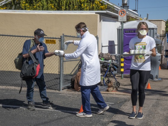 Medical students in the College of Medicine – Tucson serve food and beverages while offering health care to Tucson’s homeless population as part of the College’s Commitment to Underserved People program.