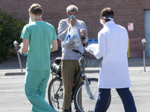 Chris Vance (right) and another College of Medicine – Tucson student offer food, drinks and medical services to the homeless population served at Z Mansion several times a week.
