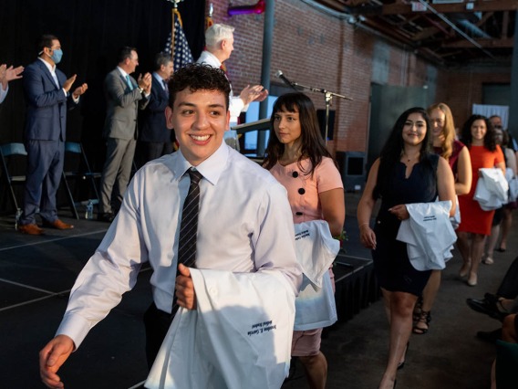 Brandon Garcia, Maëliss Gelas, Tara Ghalambor, Michelle Goforth and Rose Graf pass in front of the stage as they enter the room at the beginning of the ceremony.