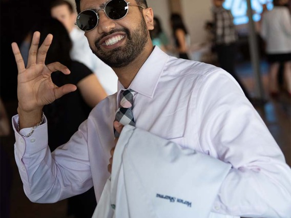 Varun Sharma pauses to give the Wildcat sign before the Class of 2024 white coat ceremony begins.