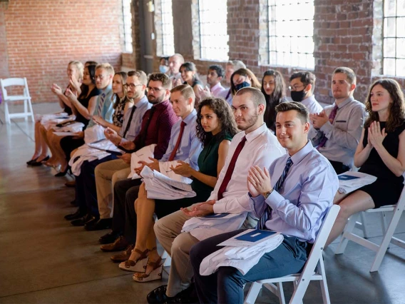 Second-year med students applaud a speaker at their long-anticipated white coat ceremony. 
